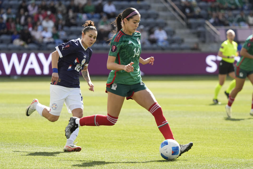 Mexico defender Greta Espinoza, right, passes in front of Paraguay forward Jessica Martinez during the first half of a CONCACAF Gold Cup women's soccer tournament quarterfinal match, Sunday, March 3, 2024, in Los Angeles. (AP Photo/Marcio Jose Sanchez)