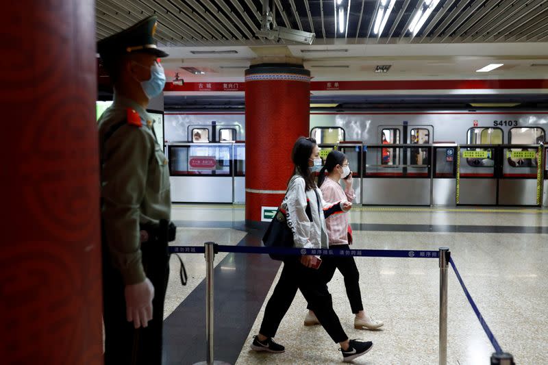 A Paramilitary police officers keeps watch at a station of Line 1 of the metro that runs past the Great Hall of the People