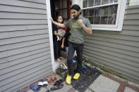 Mohammad Walizada, right, who fled Afghanistan with his family, steps out the back door of their home with two of his daughters, Zahra, left, who holds Kainat Amy, in Epping, N.H., Thursday, Sept. 15, 2022. Since the U.S. military's withdrawal from Kabul last year, the Sponsor Circle Program for Afghans has helped over 600 Afghans restart their lives in their communities. Now the Biden administration is preparing to turn the experiment into a private-sponsorship program for refugees admitted through the U.S. Refugee Admissions Program and is asking organizations to team up with it to launch a pilot program by the end of 2022. (AP Photo/Steven Senne)