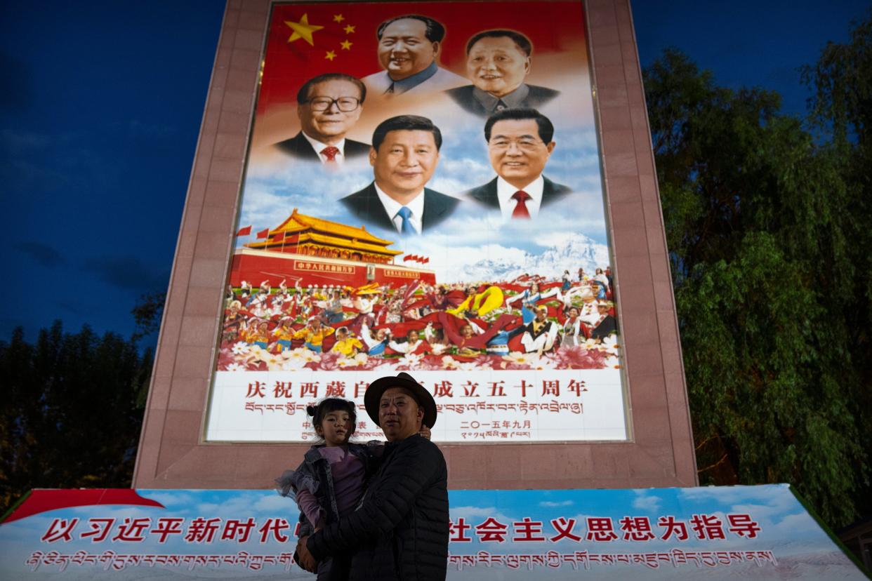 File image: A man holds a girl as they pose for a photo in front of a large mural depicting Chinese President Xi Jinping, bottom centre, and other Chinese leaders at a public square at the base of the Potala Palace in Lhasa in western China's Tibet Autonomous Region on 1 June, 2021.  (AP)