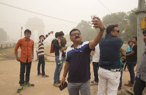 Indian tourists take selfies against the war memorial India Gate in New Delhi, India, Sunday, Nov. 6, 2016.