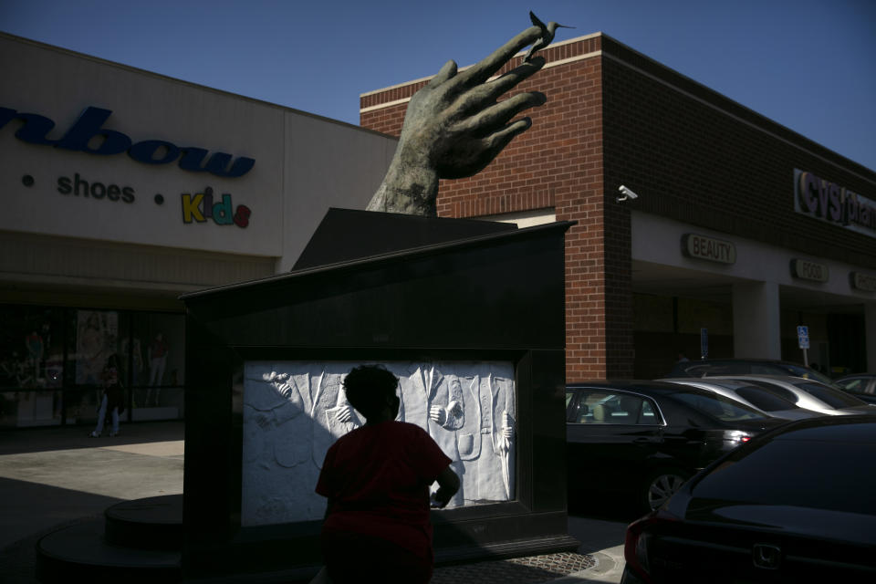 A shopper walks past a sculpture built in 1992 to honor Martin Luther King Jr. at a shopping mall named after Dr. King in the Watts neighborhood of Los Angeles, Wednesday, June 17, 2020. The Los Angeles community of Watts has long been associated with deadly and destructive rioting in 1965. This summer when widespread mostly peaceful protests for racial justice across the U.S. have been accompanied at times by vandalism and other crimes, Watts has been peaceful. One lawmaker says the residents learned long ago that it didn't pay to burn their own neighborhood. (AP Photo/Jae C. Hong)