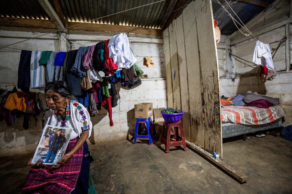 At home in her village near La Ceiba, Guatemala, Juana Cuc holds a photo of her son, Marcos Abdon Tziquin Cuc. He died in a March 27, 2023, fire at a migrant detention center in Juárez, Mexico.