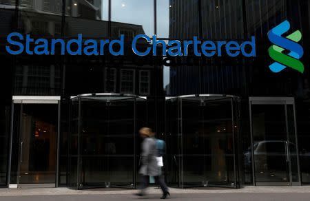 A woman walks past a Standard Chartered bank in London October 13, 2010. REUTERS/Stefan Wermuth