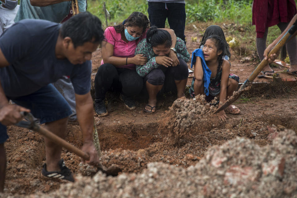 Familiares lloran durante el entierro de Manuela Chávez, quien murió por síntomas relacionados con el coronavirus a los 88 años, en la comunidad indígena Shipibo en Pucallpa, en la región peruana de Ucayali, el 31 de agosto de 2020. Los Shipibo habían tratado de evitar la llegada del virus bloqueando carreteras y aislándose. Pero en mayo muchos empezaron a tener fiebre, tos, dificultad para respirar y dolores de cabeza. (AP Foto/Rodrigo Abd)