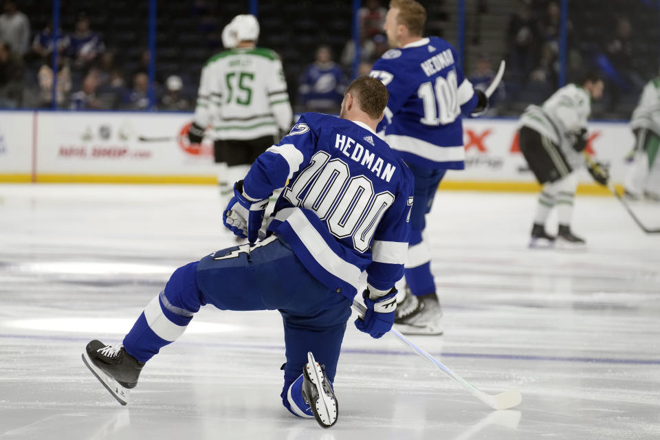 Tampa Bay Lightning's Austin Watson, foreground, stretches before an NHL hockey game against the Dallas Stars Monday, Dec. 4, 2023, in Tampa, Fla. Lightning players are wearing sweaters during warm-ups honoring defenseman Victor Hedman's 1,000th career game. (AP Photo/Chris O'Meara)
