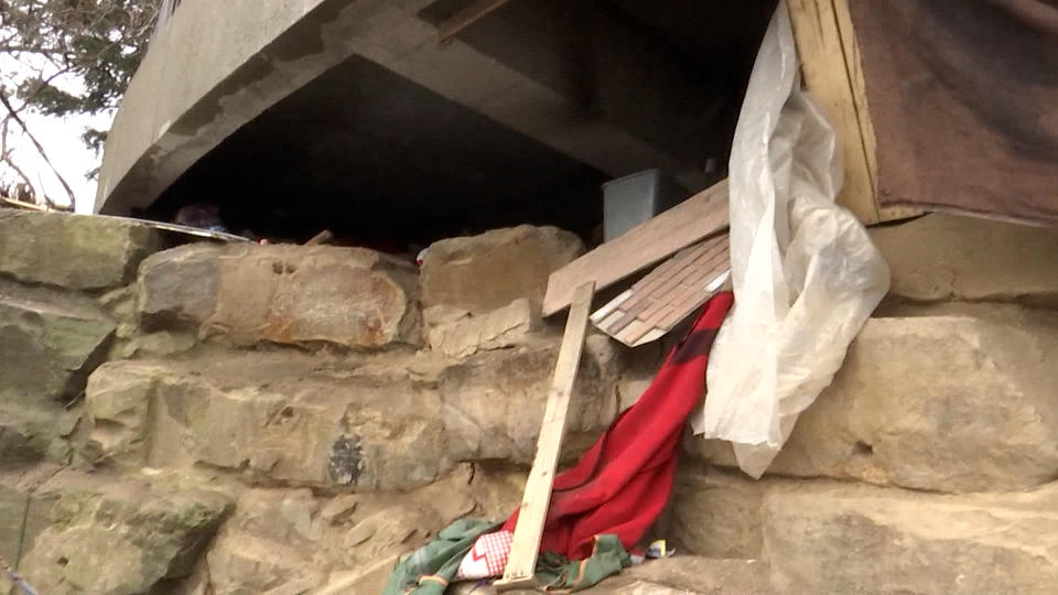 A homeless encampment under a state office building’s patio in Lansing. (WLNS)