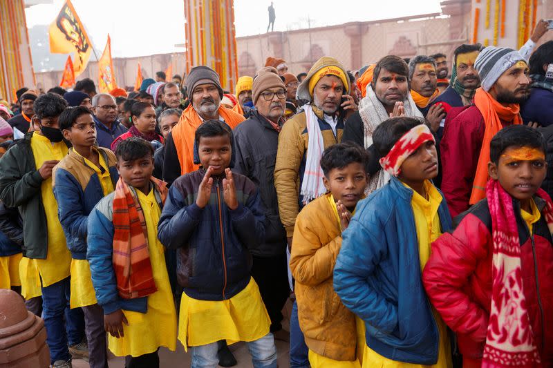 Hindu devotees stand in a queue as they wait to enter the Hindu god Lord Ram temple after its inauguration in Ayodhya