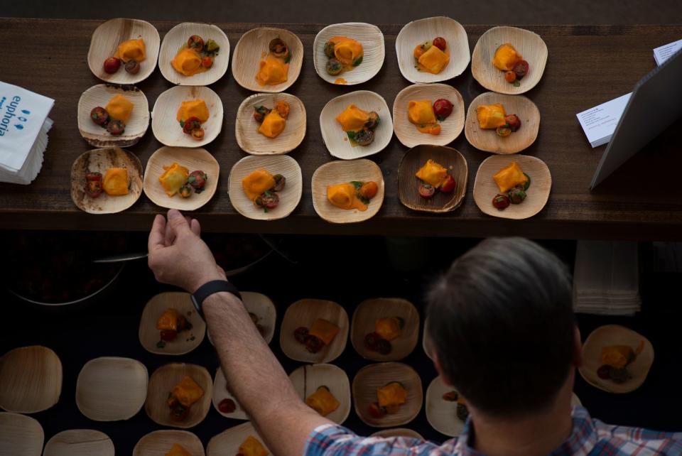 Geno Dew, from ASH Ventures in Atlanta, Ga., places dishes of burrata agnolotti during the euphoria event, "Taste of the South" held at Fluor Field Friday, Sept 20, 2019.