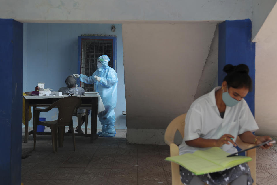 A health worker takes a nasal swab sample at a COVID-19 testing center in Hyderabad, India, Saturday, Oct. 3, 2020. India has crossed 100,000 confirmed COVID-19 deaths on Saturday, putting the country's toll at nearly 10% of the global fatalities and behind only the United States and Brazil. (AP Photo/Mahesh Kumar A.)