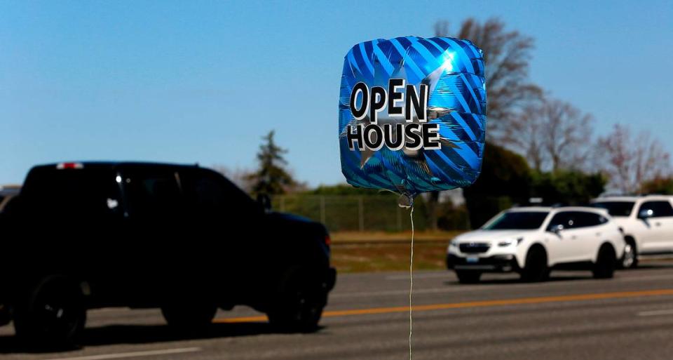 A helium filled balloon sways in the breeze along the 240 Bypass at Swift Boulevard in Richland for an open house by broker Shannon Jones of Berkshire Hathaway HomeService Central Washington.