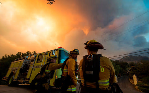 Firefighters from the Governors Office of Emergency Services monitor the advance of smoke and flames from the Thomas Fire in Montecito - Credit: AFP