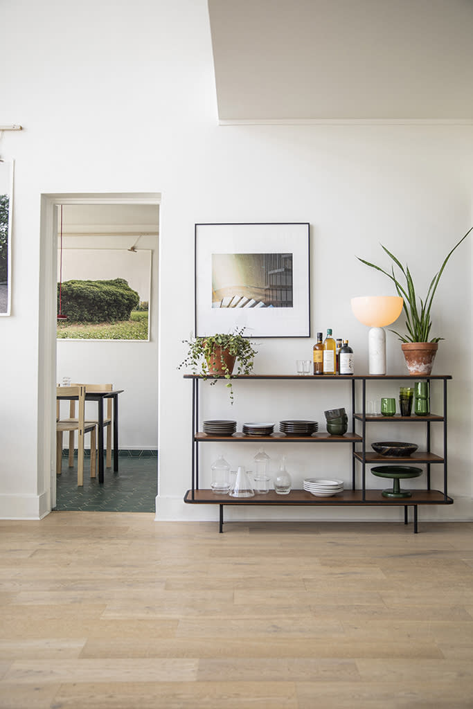 <p>Accolé à la cuisine, ce rangement bas ouvert dans le salon accueille une vaisselle sobre et design. Faisant également office de bar, ce meuble en teck cerclé de noir a pris place sous la mezzanine. Et comme à leur habitude, les propriétaires y mixent objets design, œuvres d’artistes et végétaux.</p><br>