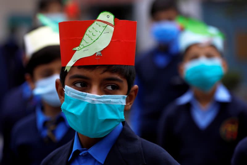 FILE PHOTO: A student wears a protective mask before entering a class with others at school as the outbreak of the coronavirus disease (COVID-19) continues, in Peshawar,