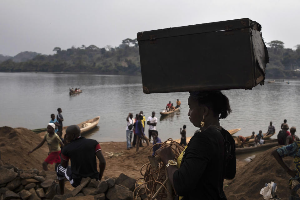 An unidentified woman carries her belongings on her head after crossing the Mbomou river back into Bangassou, Central African Republic, from Ndu in the Democratic Republic of the Congo, where she had taken refuge, Sunday Feb. 14, 2021. An estimated 240,000 people have been displaced in the country since mid-December, according to U.N. relief workers, when rebels calling themselves the Coalition of Patriots for Change launched attacks, causing a humanitarian crisis in the already unstable nation. (AP Photo/Adrienne Surprenant)