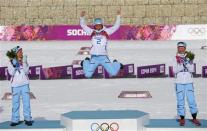 Winner Norway's Marit Bjoergen (C) celebrates next to her compatriots, second placed Therese Johaug (L) and third placed Kristin Stoermer Steira during a flower ceremony for the women's cross-country 30 km mass start free event at the Sochi 2014 Winter Olympic Games in Rosa Khutor February 22, 2014. REUTERS/Carlos Barria