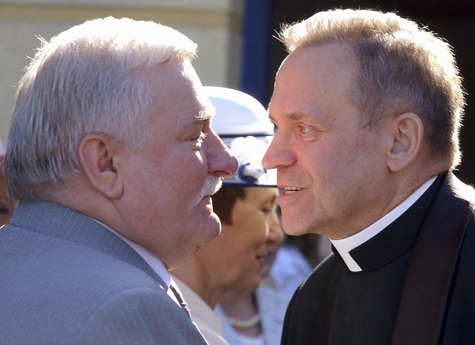 FILE - In this June 18, 2005 file photo former President Lech Walesa, left, welcomes father Henryk Jankowski at a party in Walesa's honor in Gdansk, Poland. Activists in Poland have pulled down a statue of Mgr. Henryk Jankowski after mounting allegations that he sexually abused minors. (AP Photo/Czarek Sokolowski)