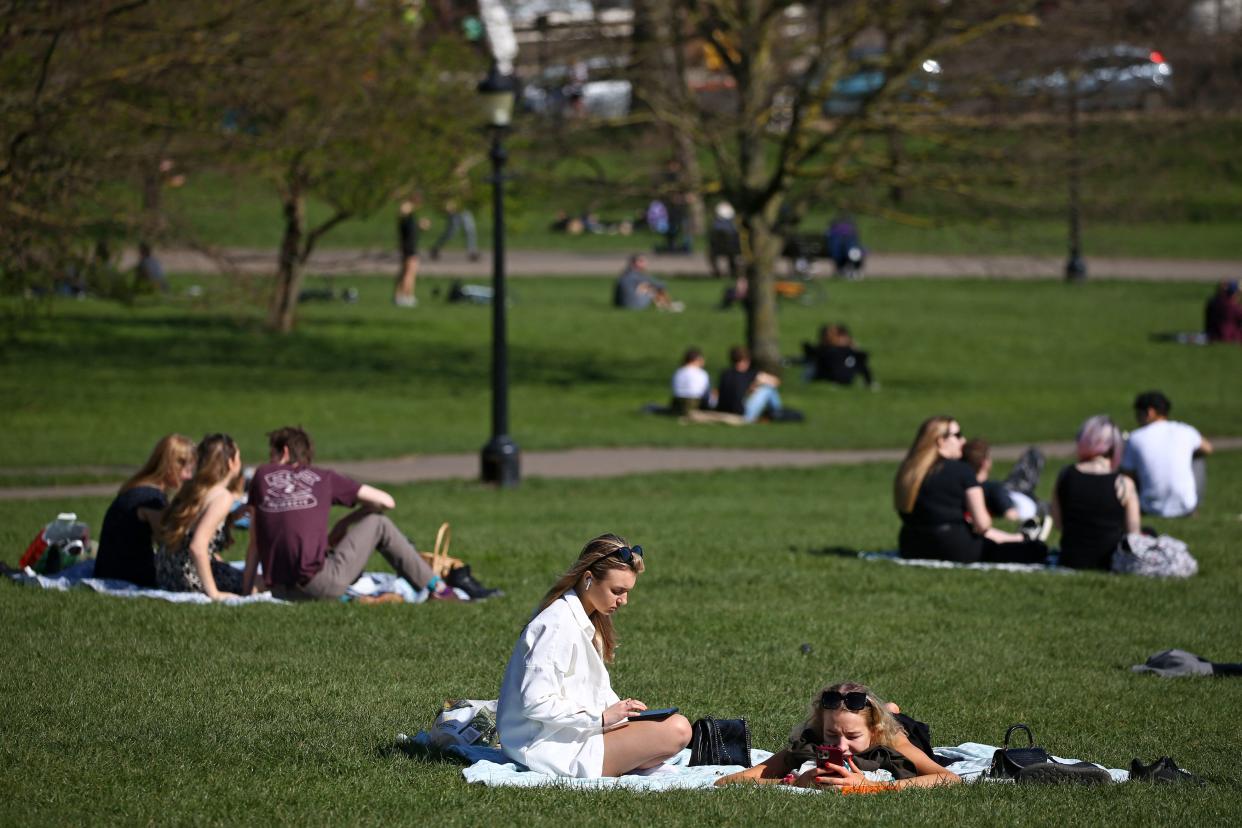 Groups of people sit and chat together in the warm weather on Primrose Hill in London on March 29, 2021, as England's third Covid-19 lockdown restrictions ease, allowing groups of up to six people to meet outside. - England began to further ease its coronavirus lockdown on Monday, spurred by rapid vaccinations, but governments in the rest of Europe struggled to contain Covid-19 surges. (Photo by Hollie Adams / AFP) (Photo by HOLLIE ADAMS/AFP via Getty Images)