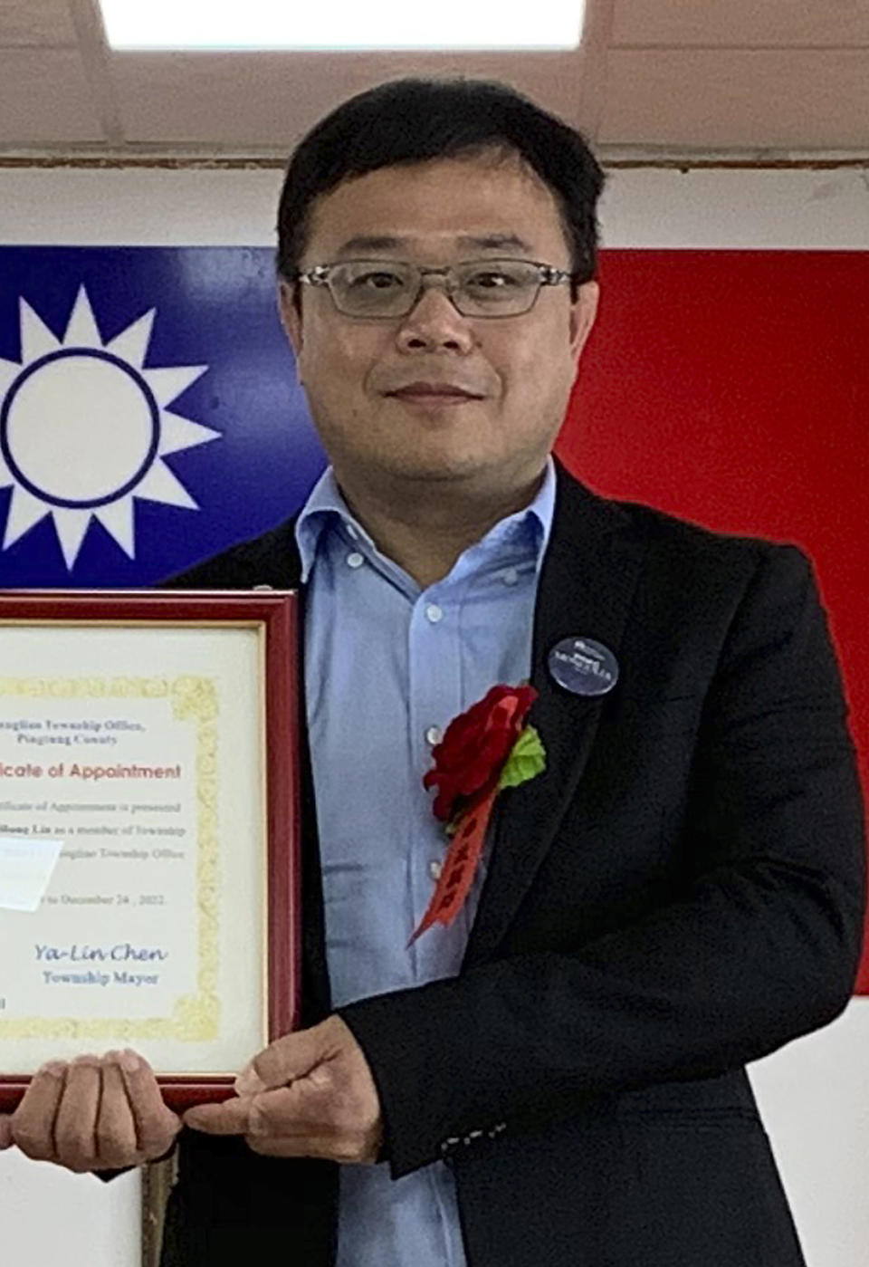 In this June 20, 2019, photo released by Pingtung County Fangliao Township Office, Lee Meng-chu accepts a certificate for his adviser role during a ceremony in Pingtung County, Southern Taiwan. Taiwan is seeking information from China about Lee who has gone missing since last week and who had reportedly distributed photos of Chinese troops just outside protest-racked Hong Kong. (Pingtung County Fangliao Township Office via AP)