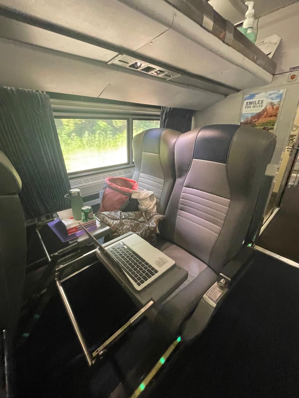 A seat on an Amtrak train set up for working remotely with a laptop on the folding table.