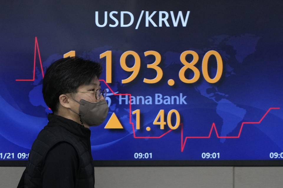 A currency trader walks by the screen showing the foreign exchange rate between U.S. dollar and South Korean won at a foreign exchange dealing room in Seoul, South Korea, Friday, Jan. 21, 2022. Shares were lower in Asia on Friday after a late afternoon sell-off wiped out gains for stocks on Wall Street. (AP Photo/Lee Jin-man)