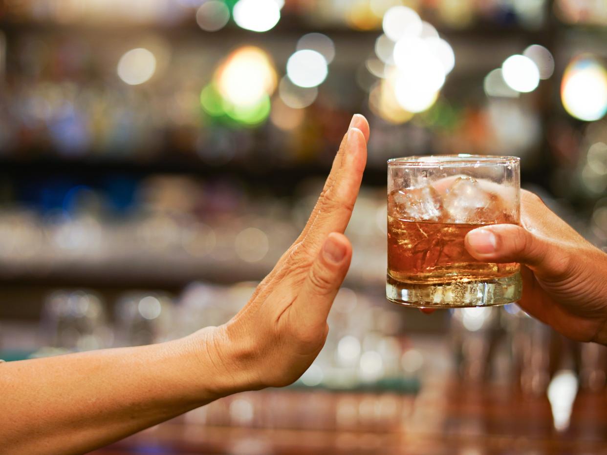 Man holding up hand to drink