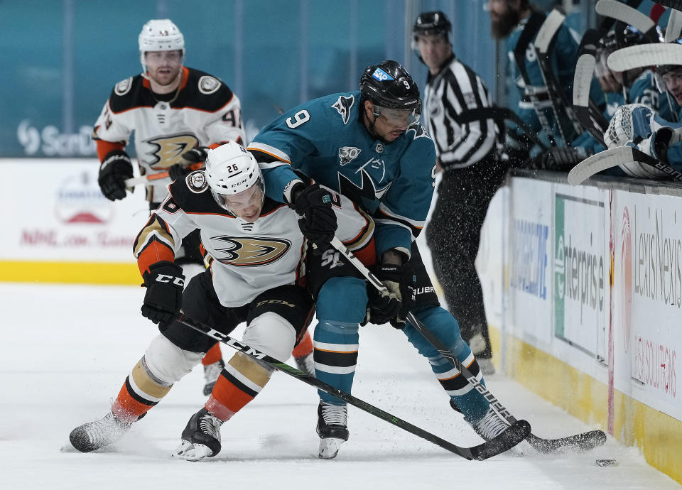 Anaheim Ducks left wing Andrew Agozzino (26) battles for the puck against San Jose Sharks left wing Evander Kane (9) during the first period of an NHL hockey game Monday, April 12, 2021, in San Jose, Calif. (AP Photo/Tony Avelar)