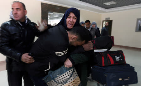 A Palestinian woman reacts as she is embraced by her son upon her return to Gaza, at Rafah border crossing in the southern Gaza Strip January 8, 2019. REUTERS/Ibraheem Abu Mustafa