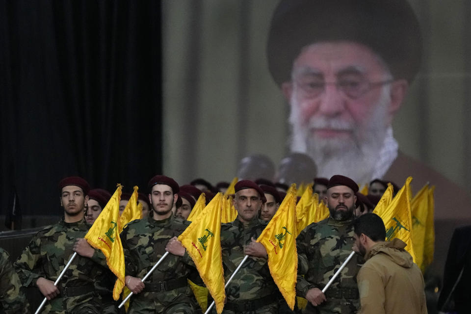 Hezbollah fighters parade in front of a poster showing Supreme Leader Ayatollah Khamenei during a rally to mark Jerusalem day, in a southern suburb of Beirut, Lebanon, Friday, April 14, 2023. Since Iran's Islamic Revolution in 1979, the rallies marking what is also known as al-Quds Day have typically been held on the last Friday of the Muslim holy month of Ramadan. (AP Photo/Hussein Malla)