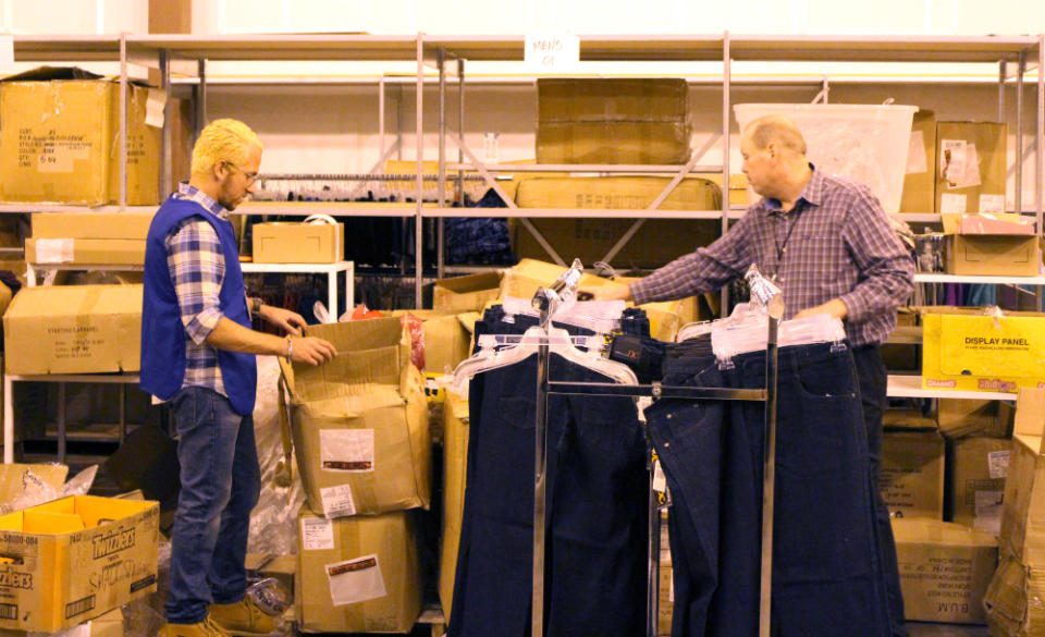 Shoppers World CEO Sam Dushey (left) opening boxes of denim on "Undercover Boss"