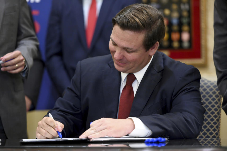 Florida Gov. Ron DeSantis signs a bill allowing the import of cheaper prescription drugs from other countries while, Tuesday, June 11, 2019, at the Eisenhower Recreation Center in The Villages, Fla. (Max Gersh/Daily Sun via AP)