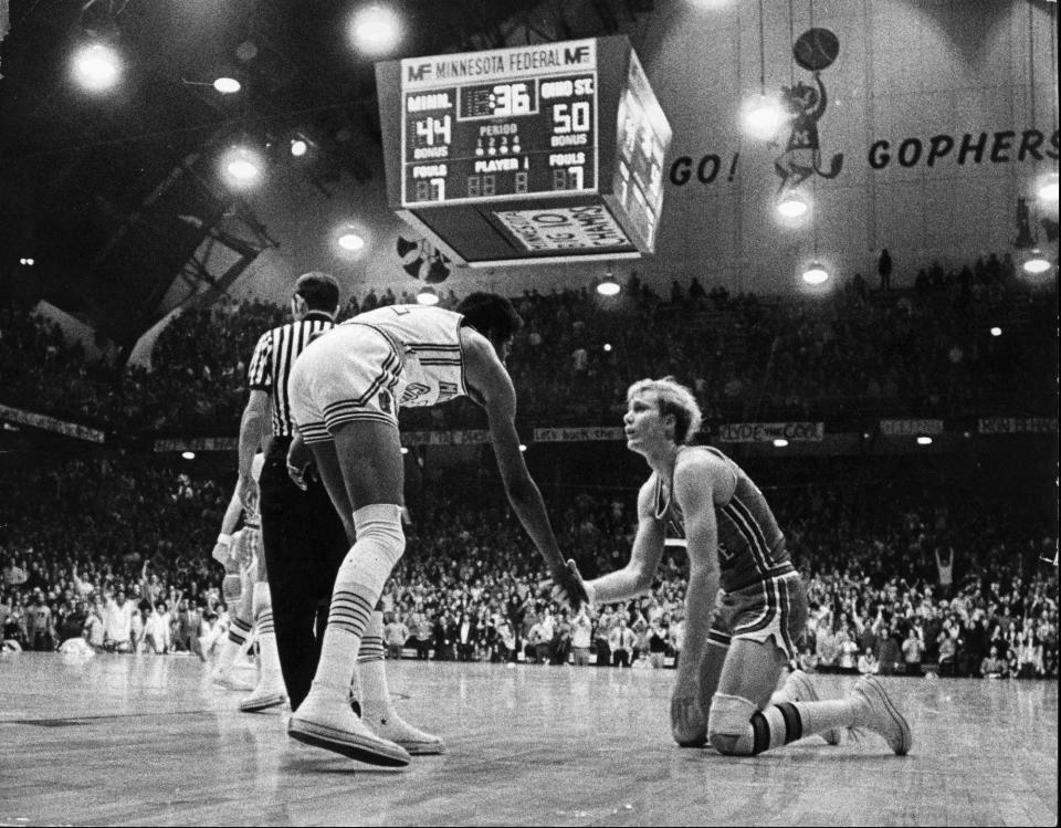 Minnesota's Corky Taylor extends a hand to Ohio State's Luke Witte after Witte was fouled by Clyde Turner. Tayor would go on to knee Witte in the groin inciting a brawl that hospitalized three Buckeye players.