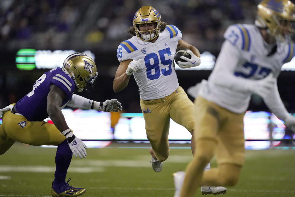 UCLA tight end Greg Dulcich (85) carries the ball as Washington linebacker Edefuan Ulofoshio, left, closes in during the second half of an NCAA college football game Saturday, Oct. 16, 2021, in Seattle. UCLA won 24-17. (AP Photo/Ted S. Warren)