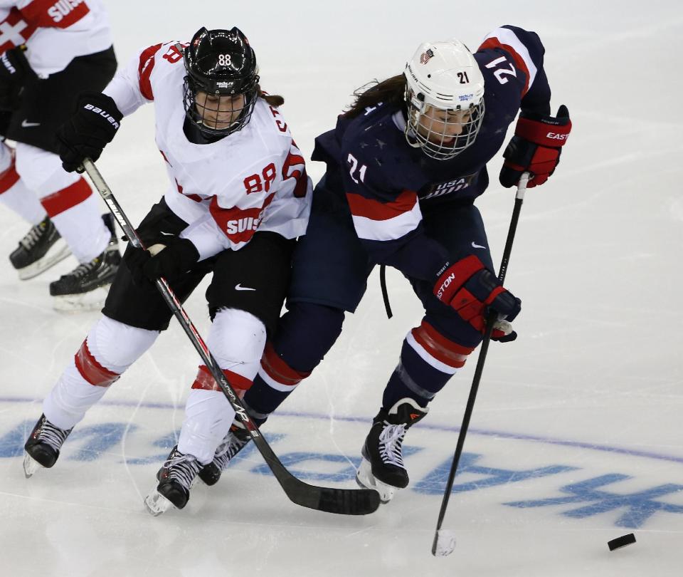 Hilary Knight of the Untied States takes the puck away from Phoebe Stanz of Switzerland during the second period of the 2014 Winter Olympics women's ice hockey game at Shayba Arena, Monday, Feb. 10, 2014, in Sochi, Russia. (AP Photo/Petr David Josek)