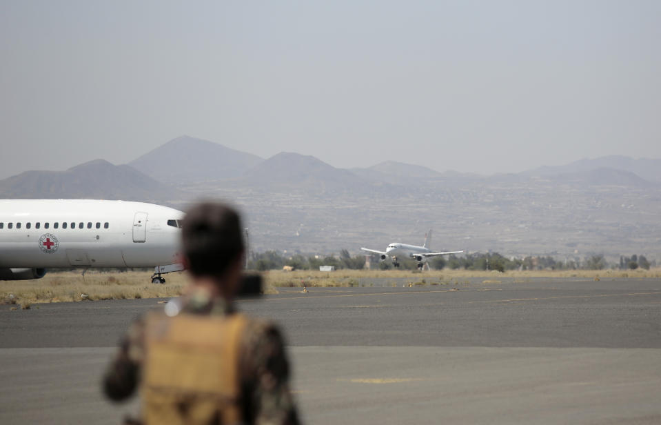 A soldier looks at planes carrying Houthi prisoners arrive after being released by the Saudi-led coalition at the airport in Sanaa, Yemen, Thursday, Oct. 15, 2020. (AP Photo/Hani Mohammed)