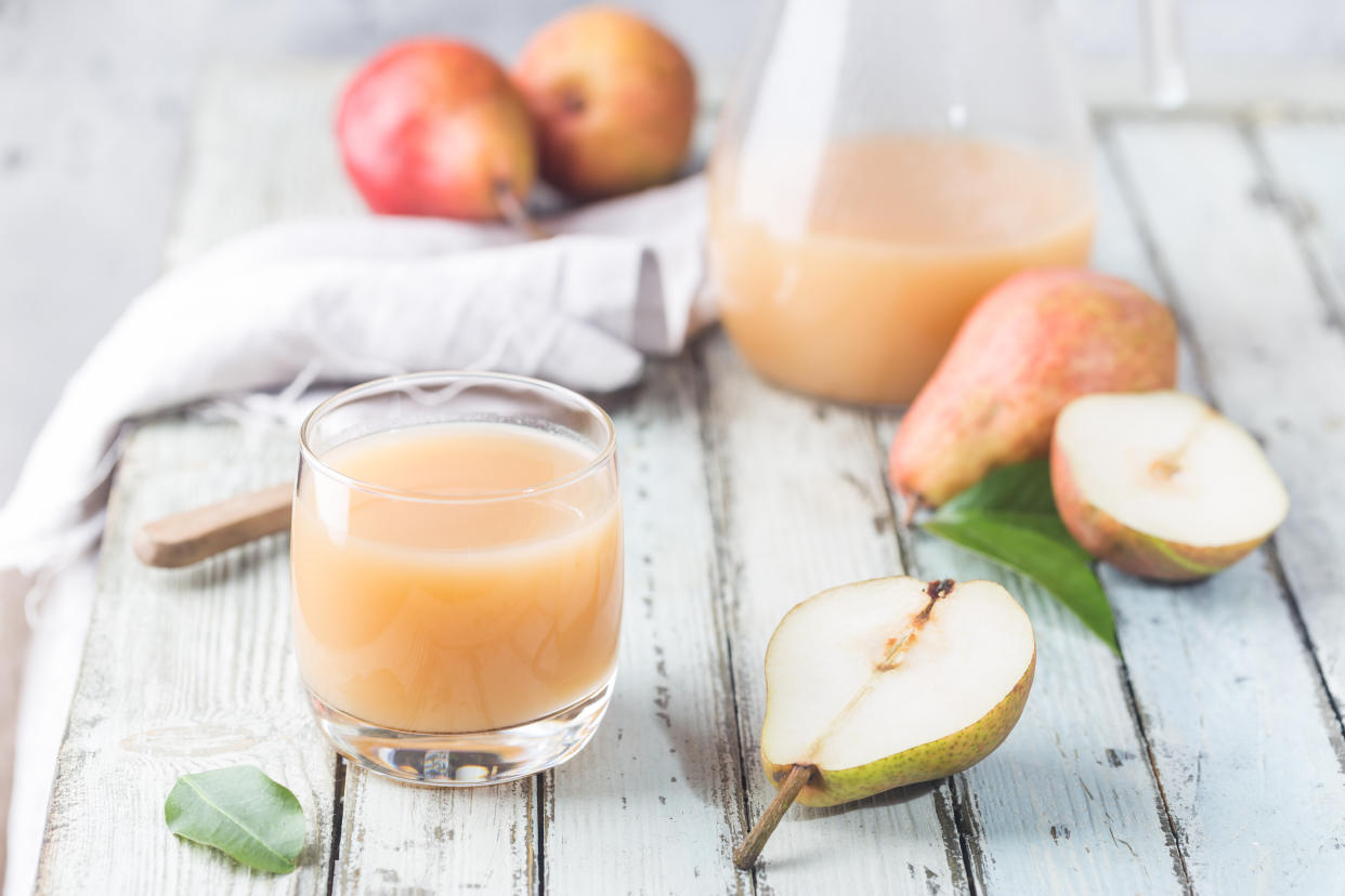 Fresh Pear Juice in a glasses with fresh fruits on light background