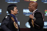 Manny Pacquiao, left, of the Philippines, and Yordenis Ugas, of Cuba, pose for photographers during a news conference Wednesday, Aug. 18, 2021, in Las Vegas. The two are scheduled to fight in a welterweight championship bout Saturday in Las Vegas. (AP Photo/John Locher)