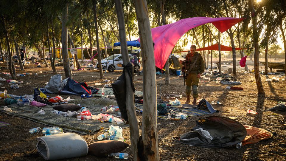 Members of security forces search for identification and personal effects at the Supernova Music Festival site where hundreds were killed and dozens taken by Hamas militants near the border with Gaza, on October 12, 2023, in Kibbutz Re'im, Israel. - Leon Neal/Getty Images