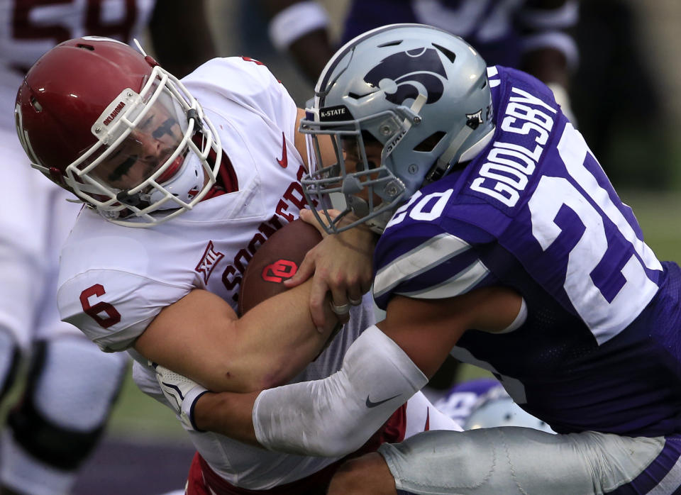 Oklahoma quarterback Baker Mayfield (6) is tackled by Kansas State defensive back Denzel Goolsby (20) during the first half of an NCAA college football game in Manhattan, Kan., Saturday, Oct. 21, 2017. (AP Photo/Orlin Wagner)