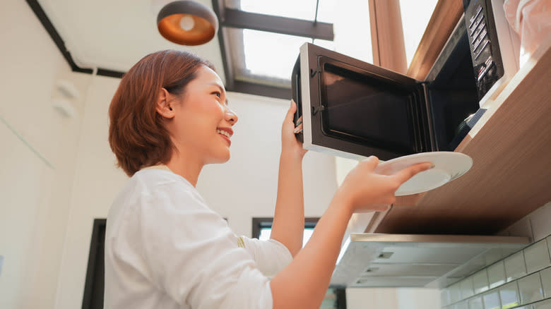 Woman opening microwave