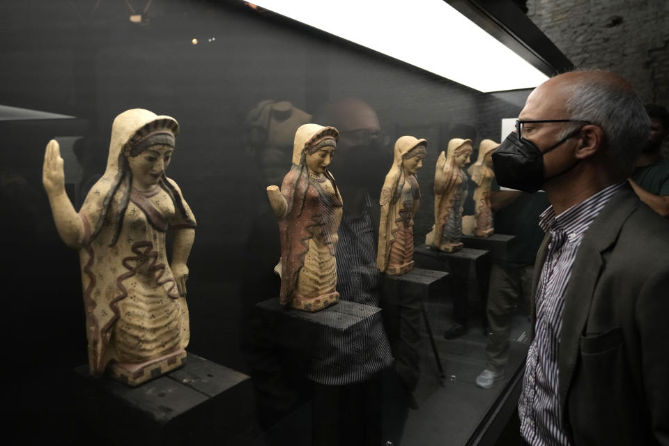 A man looks at archeological artifacts displayed in the new "Museum of Rescued Art" in Rome, Wednesday, June 15, 2022. Italy has been so successful in regaining ancient artworks and artifacts illegally exported from the country that it has now created a museum just for them, the Museum of Rescued Art, inaugurated on Wednesday in the cavernous Octagonal Hall of the ancient Baths of Diocletian. (AP Photo/Alessandra Tarantino)