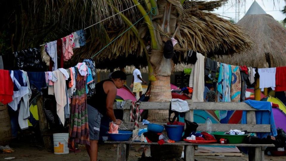 Una mujer lava la ropa en el campamento Necocli en Colombia.