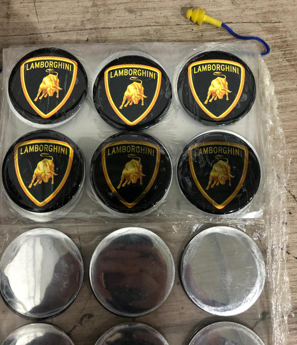 This July 15, 2019 photo released by Itajai Civil Police shows emblem badges stamped with the Lamborghini logo, inside a workshop in Itajai, Brazil. Brazilian police dismantled the clandestine workshop run by a father and son who assembled fake Ferraris and Lamborghinis, in Brazil's southern state of Santa Catarina. (Itajai Civil Police via AP) (Itajai Civil Police via AP)