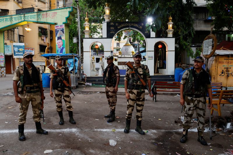 Central Reserve Police Force officials stand guard on a street before voting begins during the fifth phase of India's general election, in Mumbra