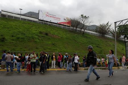 People queue in a street outside a supermarket to try to buy basic food items in Caracas, Venezuela, May 15, 2016. REUTERS/Marco Bello