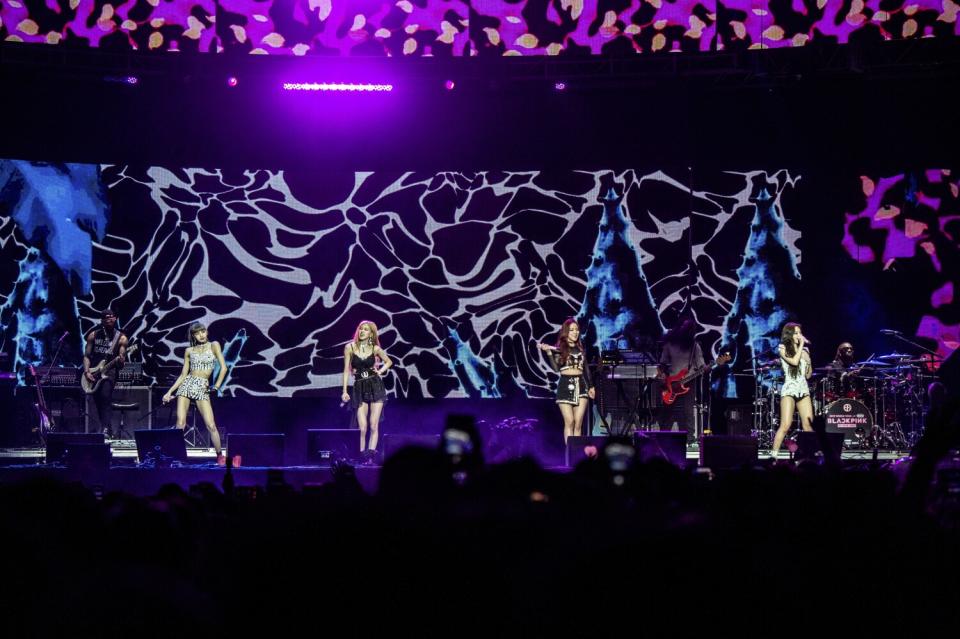 Four women perform on a stage.