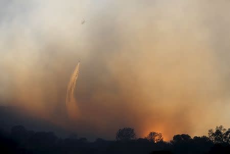 A helicopter drops water on the Wagg Fire near Lake Berryessa, California July 23, 2015. REUTERS/Robert Galbraith