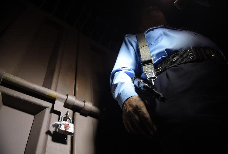 A Pakistani policeman stands guard outside the office of the international charity 'Save the Children' sealed by order of Pakistani authorities in Islamabad on June 11, 2015