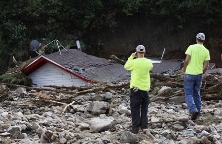 Boulder County workers look at a destroyed house in Jamestown, Colorado, after a flash flood destroyed much of the town, September 14, 2013. REUTERS/Rick Wilking