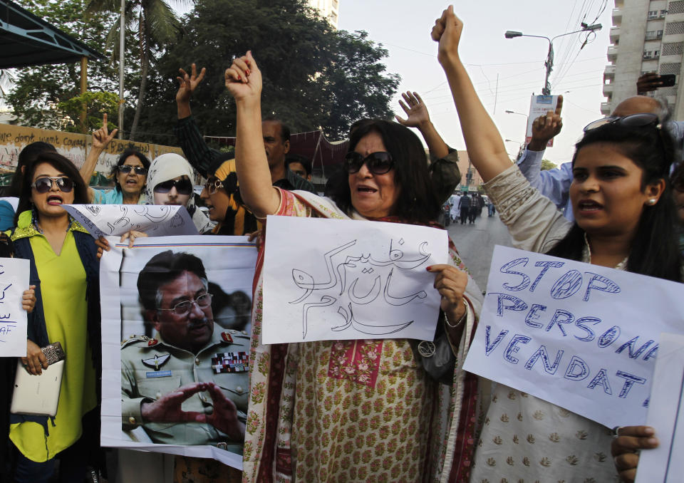 Supporters of Pakistan's former president and military ruler Pervez Musharraf chant slogans in his support in Karachi, Pakistan, Wednesday, April 2, 2014. State-run Pakistan Television said Pakistan’s interior ministry has rejected a request from the country’s former military ruler Pervez Musharraf to go abroad for his own treatment and to see his ailing mother. The placard, center, reads, "Salute to great mother." (AP Photo/Fareed Khan)